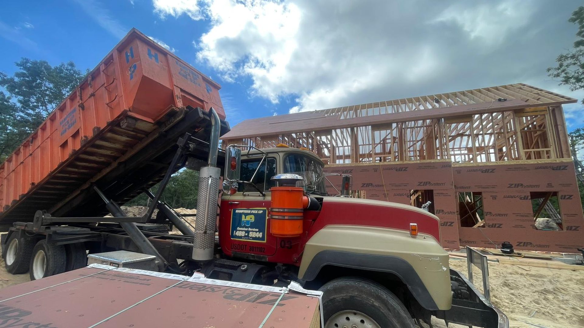 A Hamptons Pick Up roll-off dumpster truck on a job in Bridgehampton, NY