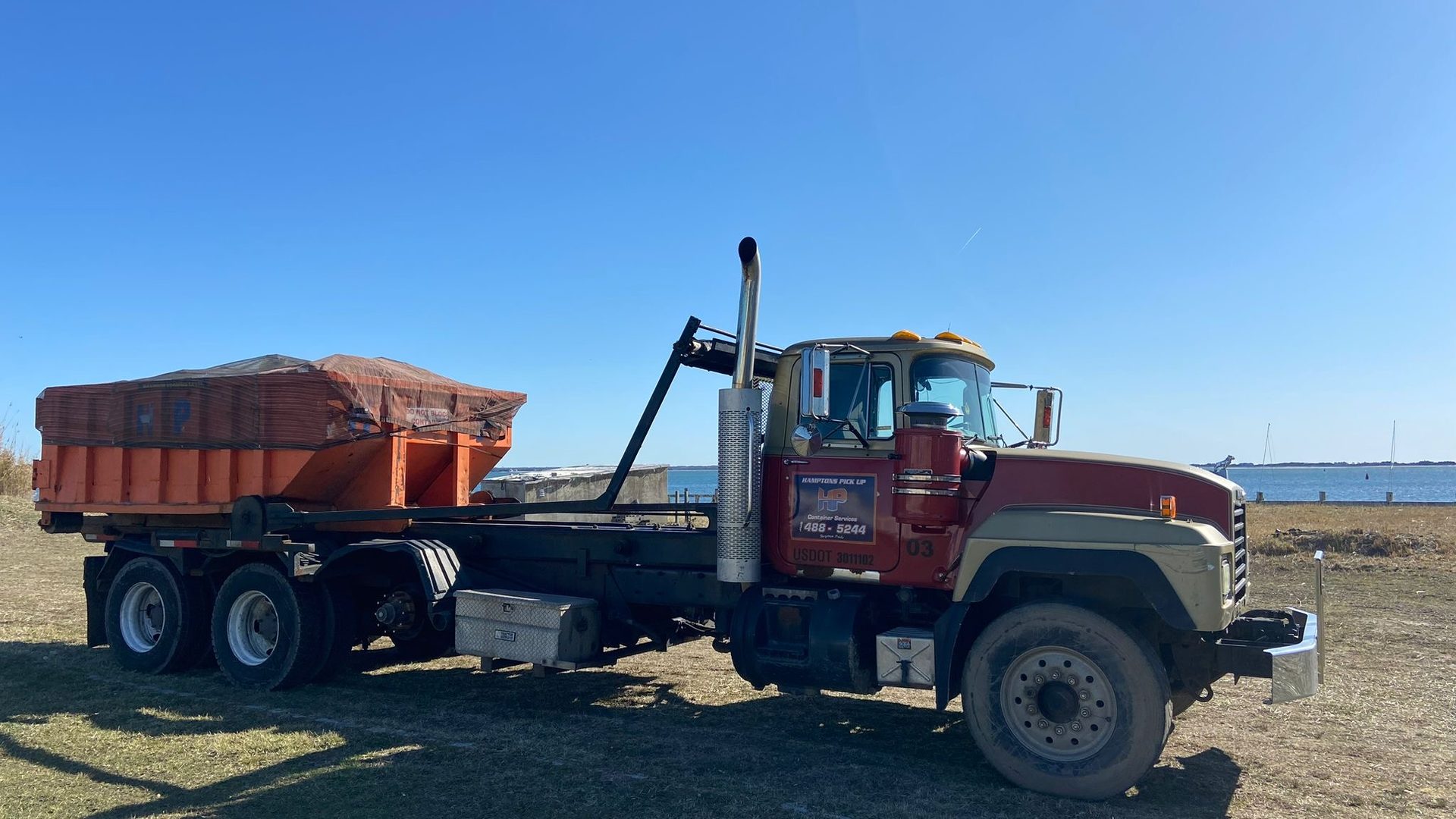 A Hamptons Pick Up roll-off dumpster truck on a job in Cutchogue, NY