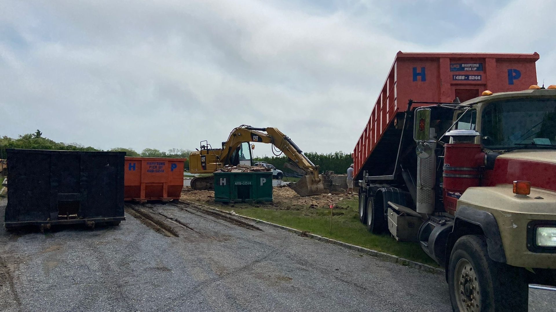 A Hamptons Pick Up roll-off dumpster truck on a job in Greenport, NY