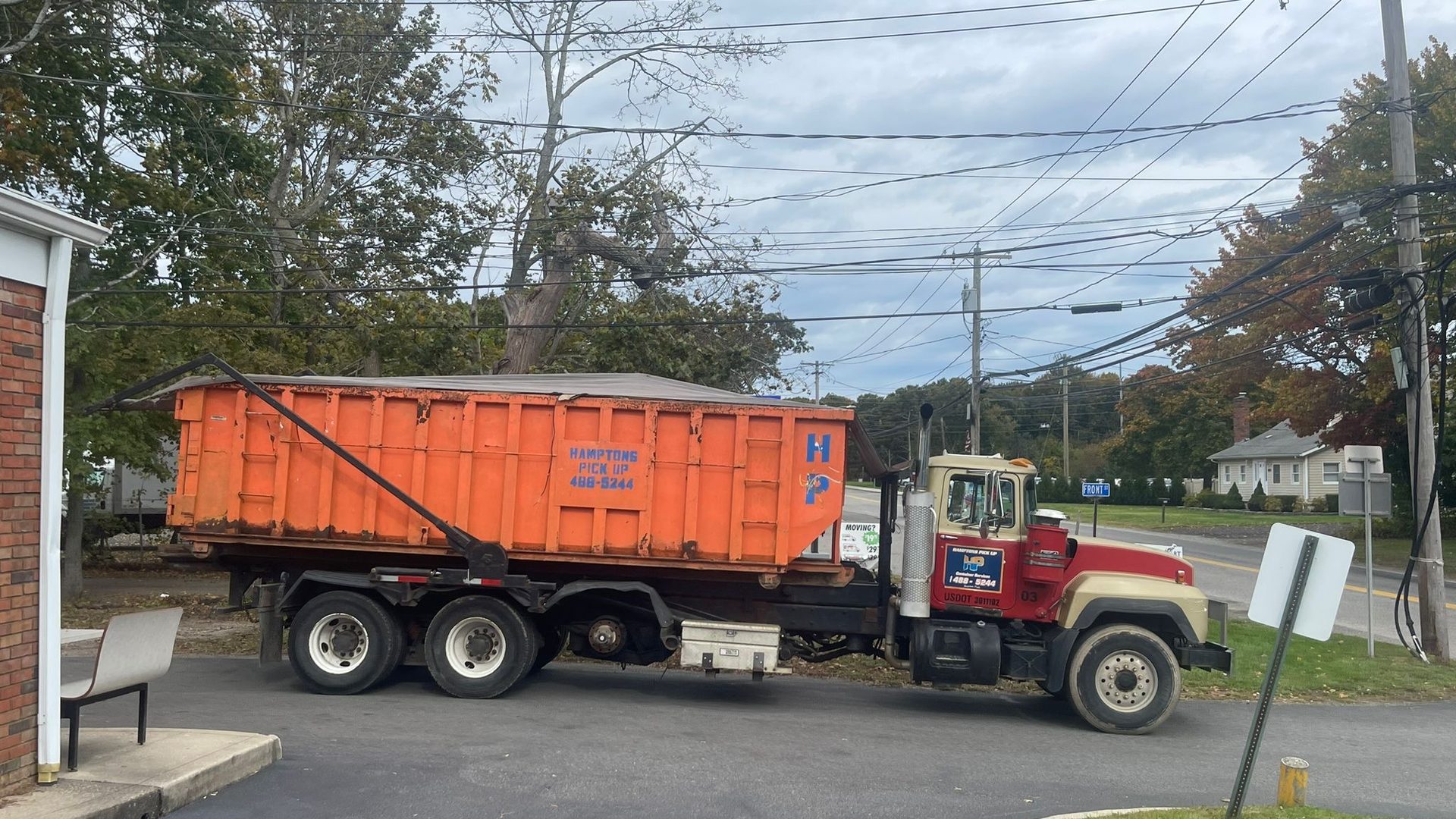 A Hamptons Pick Up roll-off dumpster truck on a job in Jamesport, NY