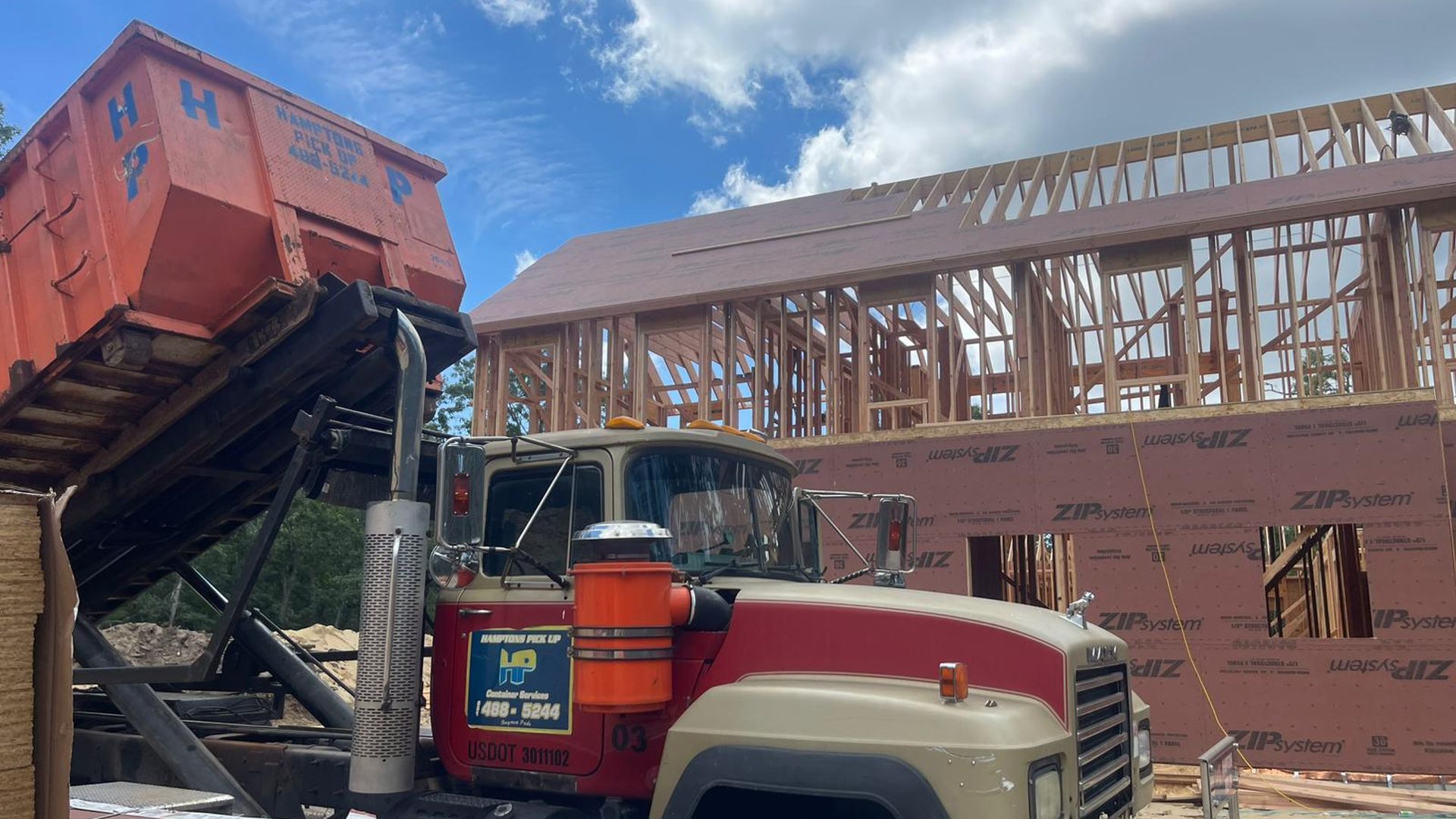 A Hamptons Pick Up roll-off dumpster truck on a job in Orient, NY