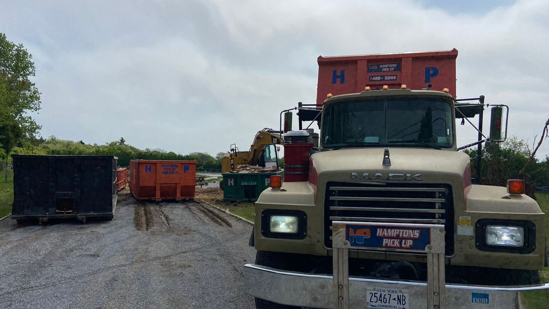 A Hamptons Pick Up roll-off dumpster truck on a job in Peconic, NY