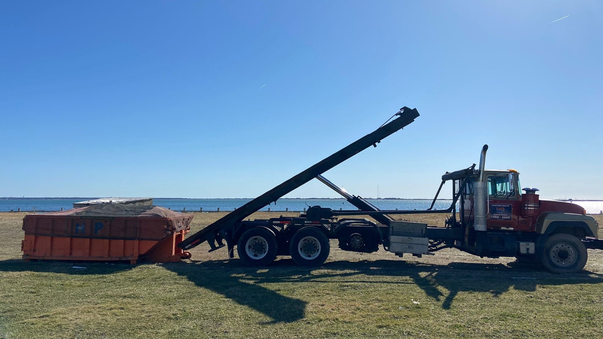 A Hamptons Pick Up roll-off dumpster truck on a job in Sag Harbor, NY