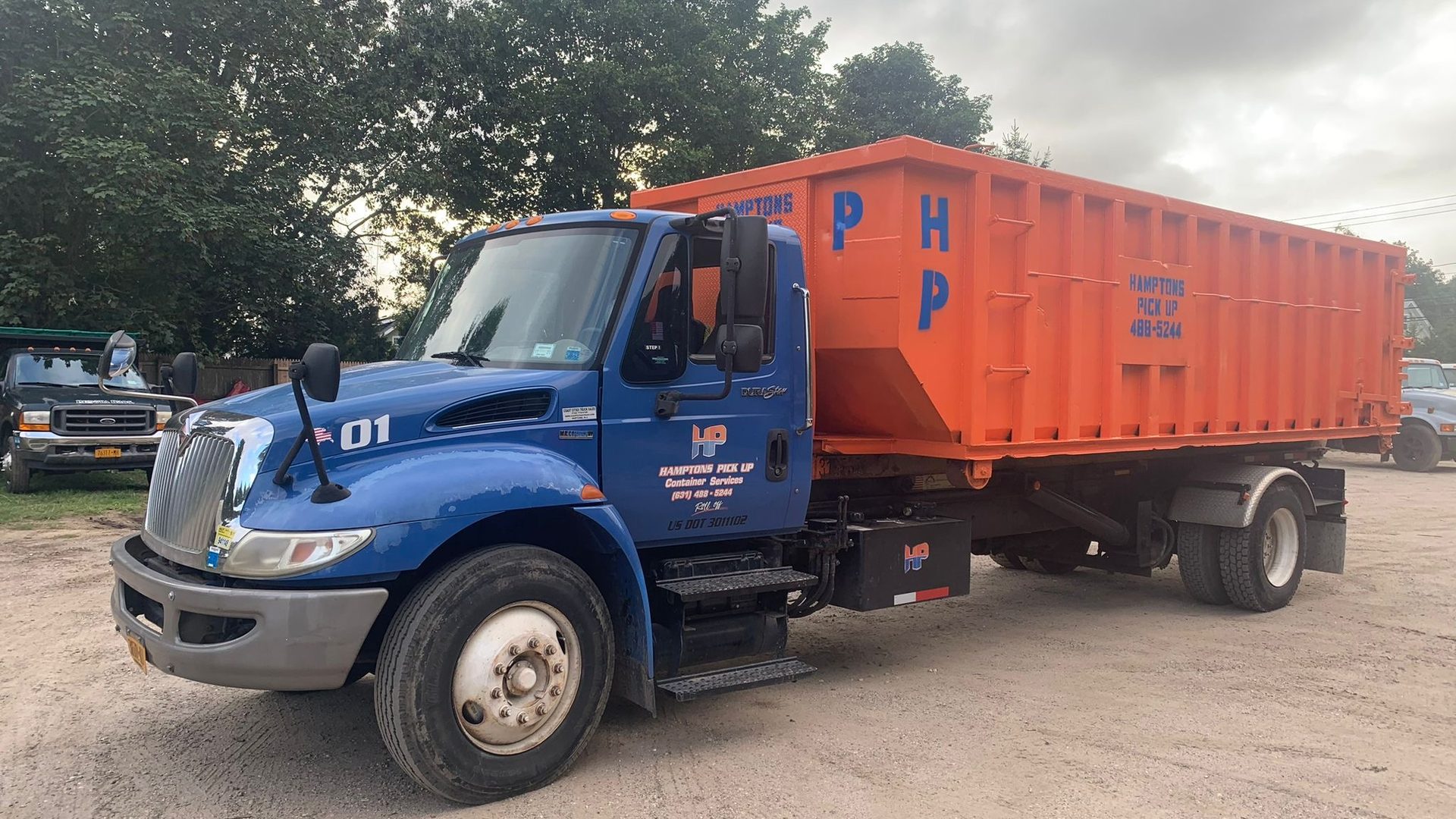 A Hamptons Pick Up roll-off dumpster truck on a job in Water Mill, NY